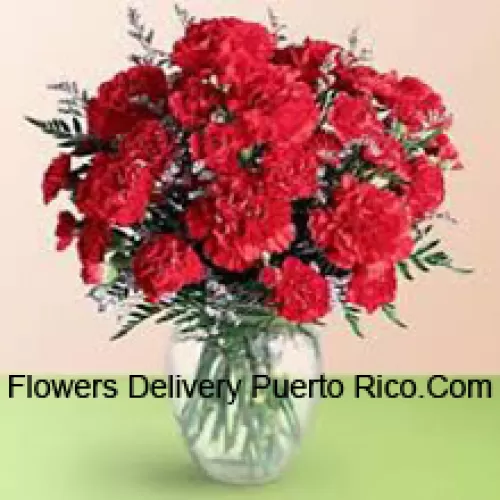 37 Red Carnations With Seasonal Fillers In A Glass Vase