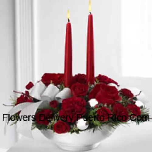 Our Holiday Elegance Centerpiece will add that special spark to their seasonal celebration with its vibrant array of crimson blooms! Red roses, carnations and spray roses sit amongst holiday greens in a posh ceramic?silver container adorned with a beautiful silver ribbon accent and two taper candles to bring a holiday glow of warmth and peace to their table. (Please Note That We Reserve The Right To Substitute Any Product With A Suitable Product Of Equal Value In Case Of Non-Availability Of A Certain Product)